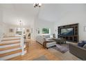 Bright living room with vaulted ceilings, a large entertainment center, and a staircase to the second floor at 11263 Vrain Dr, Westminster, CO 80031