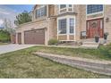View of the two-car garage and front entrance to the home at 11710 Crow Hill Dr, Parker, CO 80134