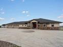 Expansive ranch home featuring stone accents and a large circular driveway for ample parking at 14025 Florence Ct, Brighton, CO 80602