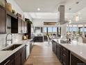 Gourmet kitchen featuring dark cabinets, white countertops, and stainless steel appliances open to the dining area at 14025 Florence Ct, Brighton, CO 80602