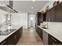 Spacious kitchen with large island, modern appliances, and dark cabinetry with a seamless design at 14025 Florence Ct, Brighton, CO 80602