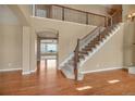 Elegant home entryway with hardwood floors, staircase, and arched doorway leading to spacious living area at 3873 Fairbrook Pt, Highlands Ranch, CO 80130