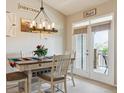 Cozy dining area with stylish lighting fixture, a table for four, and access to an outdoor space at 22932 E Ontario Dr # 102, Aurora, CO 80016