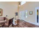 Bright living room with soaring ceilings, hardwood floors, and natural light at 8807 Tuscany Ln, Highlands Ranch, CO 80130