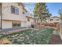 Spacious backyard featuring a wooden deck, stone retaining wall, and lush green lawn at 2210 S Oakland Way, Aurora, CO 80014