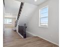 Modern staircase with dark wood railings in a light-colored hallway at 24540 E 36Th Ave, Aurora, CO 80019