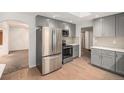 Modern kitchen featuring stainless steel appliances and gray cabinetry at 6613 Independence St, Arvada, CO 80004