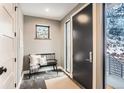 Inviting entryway with sleek black door, bench seating, and a view to the outdoors through a side window at 795 Pine Brook Rd, Boulder, CO 80304