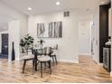 Dining area with a modern glass table, seating for four, and contemporary artwork at 35 Everett St, Lakewood, CO 80226