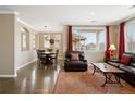 Elegant living room featuring hardwood floors, neutral walls, and comfortable seating arrangement near the dining area at 10127 Bluffmont Ln, Lone Tree, CO 80124