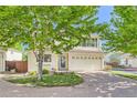 Charming two-story home featuring a brick driveway, a two-car garage and neutral toned siding at 20000 Mitchell Pl # 51, Denver, CO 80249