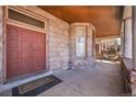 Inviting front porch with stone columns and a wood-paneled ceiling, leading to a sturdy red front door at 54 S Emerson St # 4, Denver, CO 80209