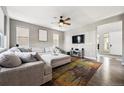 Bright living room featuring a comfortable sectional sofa, ceiling fan, and wall-mounted television for entertainment at 18083 Telford Ave, Parker, CO 80134