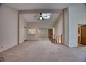 Bright living room features carpeted floors, ceiling fan, and a skylight for natural light at 11946 E Maple Ave, Aurora, CO 80012