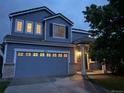 Exterior shot of home at dusk, highlighting the attached garage and covered front porch with column supports at 8416 S Reed St, Littleton, CO 80128
