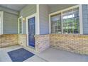 Cozy front porch featuring brick accents, a blue front door, and an inviting entry space at 8416 S Reed St, Littleton, CO 80128