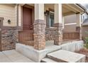 Inviting front porch with stone pillars and wood railing, leading to a stylish front door at 3522 Harvard Pl, Broomfield, CO 80023