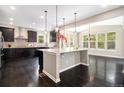 Modern kitchen featuring a large island, dark cabinets, and stainless steel appliances at 3522 Harvard Pl, Broomfield, CO 80023