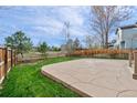 Lawn area with an extended concrete patio, fenced yard, and mature trees at 1544 E Weldona Way, Superior, CO 80027