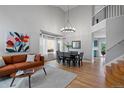 Bright living room with tall ceilings, modern chandelier, wood floors, and ample natural light at 1544 E Weldona Way, Superior, CO 80027