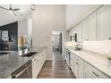 Modern kitchen with granite countertops, white cabinets, stainless steel appliances, and hardwood floors at 2279 E 129Th Ave, Thornton, CO 80241
