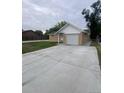 Exterior view shows the house with a long concrete driveway and attached garage at 8220 E 104Th Way, Henderson, CO 80640