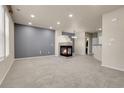 Spacious living room featuring a modern fireplace, neutral carpet, recessed lighting, and a contemporary color scheme at 12793 Leyden St # D, Thornton, CO 80602