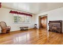 Inviting living room boasts gleaming hardwood floors, a bright window with curtains, and an antique piano at 541 Yucca Hills Rd, Castle Rock, CO 80109