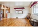 Spacious living room with original hardwood flooring, large window, and decorative trim, offering natural light at 541 Yucca Hills Rd, Castle Rock, CO 80109