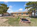 Spacious backyard with lush lawn, mature trees, quaint garden pond, storage shed, and a well-kept patio at 4295 S County Road 193, Byers, CO 80103