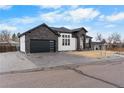 Contemporary home exterior features stone accents, a black garage door, and a well-maintained driveway at 12215 Viewpoint Dr, Lakewood, CO 80401