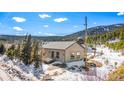 Exterior shot of a cozy cabin-style home with snowy surroundings and a mountain backdrop at 445 Beaver Rd # 4, Idaho Springs, CO 80452