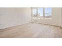 Spacious living room with light wood flooring, neutral walls, and large windows offering abundant natural light at 6562 Arbor Blvd # 1, Thornton, CO 80602