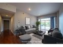 Bright living room featuring a modern sofa, stylish decor, and sliding doors to a large outdoor balcony at 6000 W Floyd Ave # 107, Denver, CO 80227