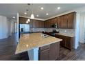 Modern kitchen with stainless steel appliances, granite countertops, and center island at 1055 Snowberry Ave, Elizabeth, CO 80107