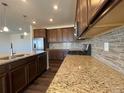 Granite countertops, stainless steel appliances, tile backsplash, and dark wood flooring in kitchen at 1055 Snowberry Ave, Elizabeth, CO 80107