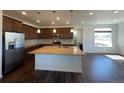 Open-concept kitchen with an island, stainless steel appliances, and an adjacent living space at 1055 Snowberry Ave, Elizabeth, CO 80107