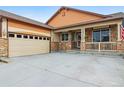 Charming home with stone accents, front porch, attached garage, and driveway at 2958 S Lisbon Way, Aurora, CO 80013