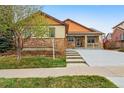 Charming home with stone accents, front porch, attached garage, and driveway at 2958 S Lisbon Way, Aurora, CO 80013