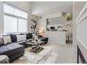 Bright and airy living room boasts a modern sectional sofa, stylish decor, and seamless flow into the adjacent kitchen at 6444 Silver Mesa Dr # A, Highlands Ranch, CO 80130