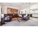 Inviting living room featuring a comfortable leather sofa, shelving and view of the kitchen at 8622 S Everett St, Littleton, CO 80128