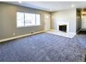 Comfortable living room featuring a fireplace, neutral walls and plush carpeting at 6717 Lee St, Arvada, CO 80004