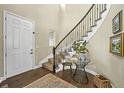 Elegant foyer featuring a curved staircase with iron railings and hardwood flooring, complemented by stylish decor at 15033 Delhi Ave, Parker, CO 80134