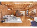 Spacious living room showcasing exposed brick, wood ceilings, an open layout, and a spiral staircase at 1125 E Kentucky Ave, Denver, CO 80209