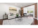 Inviting living room with exposed brick, white sofa, and natural light at 1832 W 36Th Ave, Denver, CO 80211