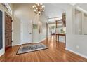 Bright foyer with hardwood floors, chandelier, and view of the second floor at 9315 E Aspen Hill Ln, Lone Tree, CO 80124