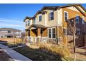 Two-story townhome showcasing neutral exterior paint, a cozy porch, and low-maintenance landscaping at 13725 Ash Cir, Thornton, CO 80602