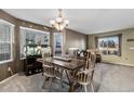 Bright dining room with natural light, a modern chandelier, and an adjacent living area at 11866 High Desert Rd, Parker, CO 80134