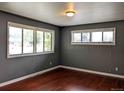 Inviting living room with hardwood floors, featuring two large windows for abundant sunlight at 1500 S Perry St, Denver, CO 80219
