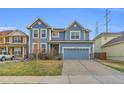 Charming two-story home with a blue exterior, a spacious driveway, and well-maintained landscaping at 17216 E Trailmaster Dr, Parker, CO 80134